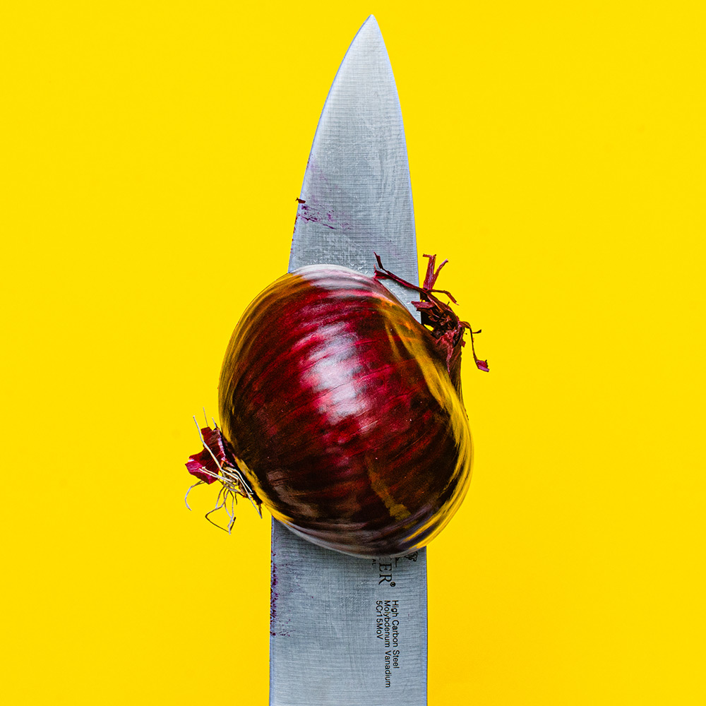 un couteau avec un oignon rouge